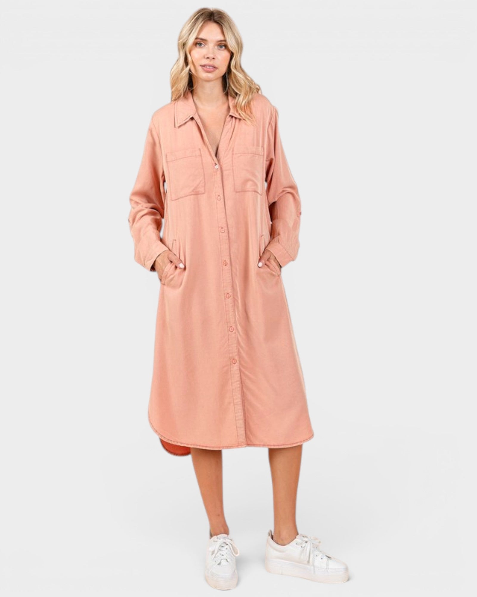 Woman wearing a pink shirt dress on a white background