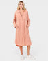 Woman wearing a pink shirt dress on a white background