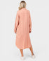 Person wearing a long peach-colored dress on a white background