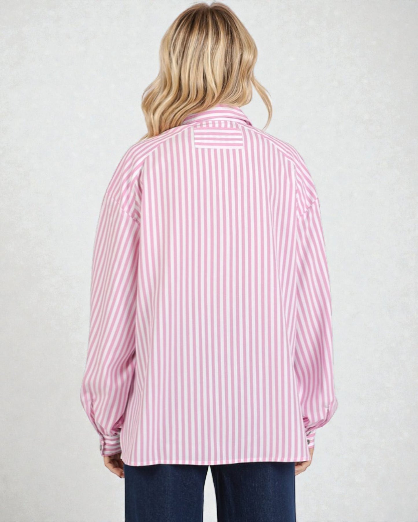 Person wearing a pink and white striped shirt on a plain background