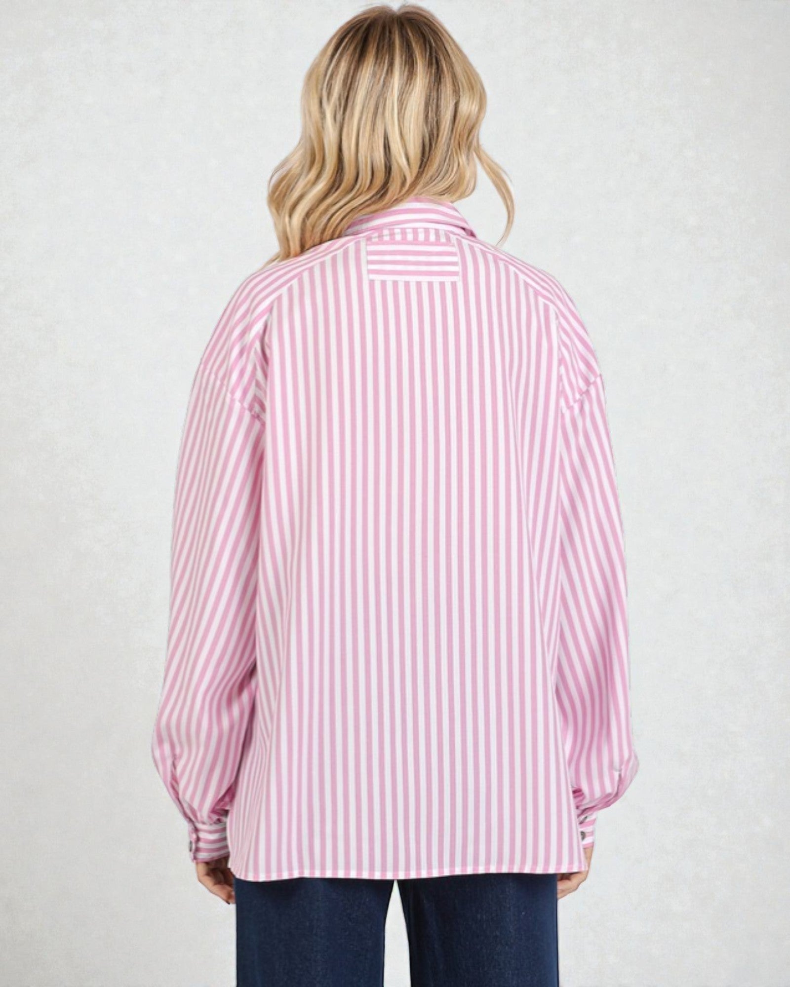 Person wearing a pink and white striped shirt on a plain background