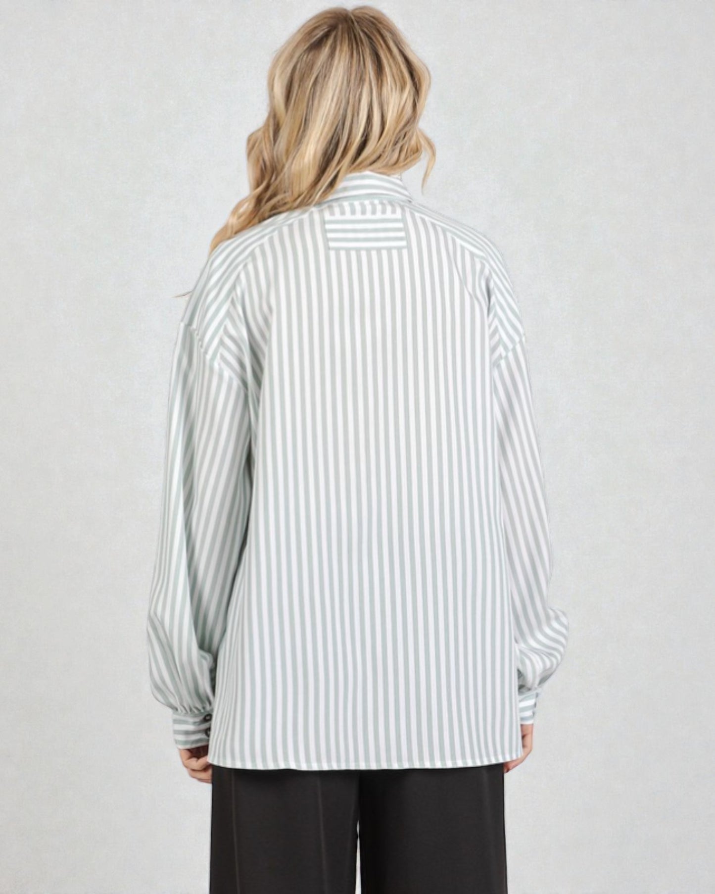 Person wearing a striped shirt with long sleeves on a plain background