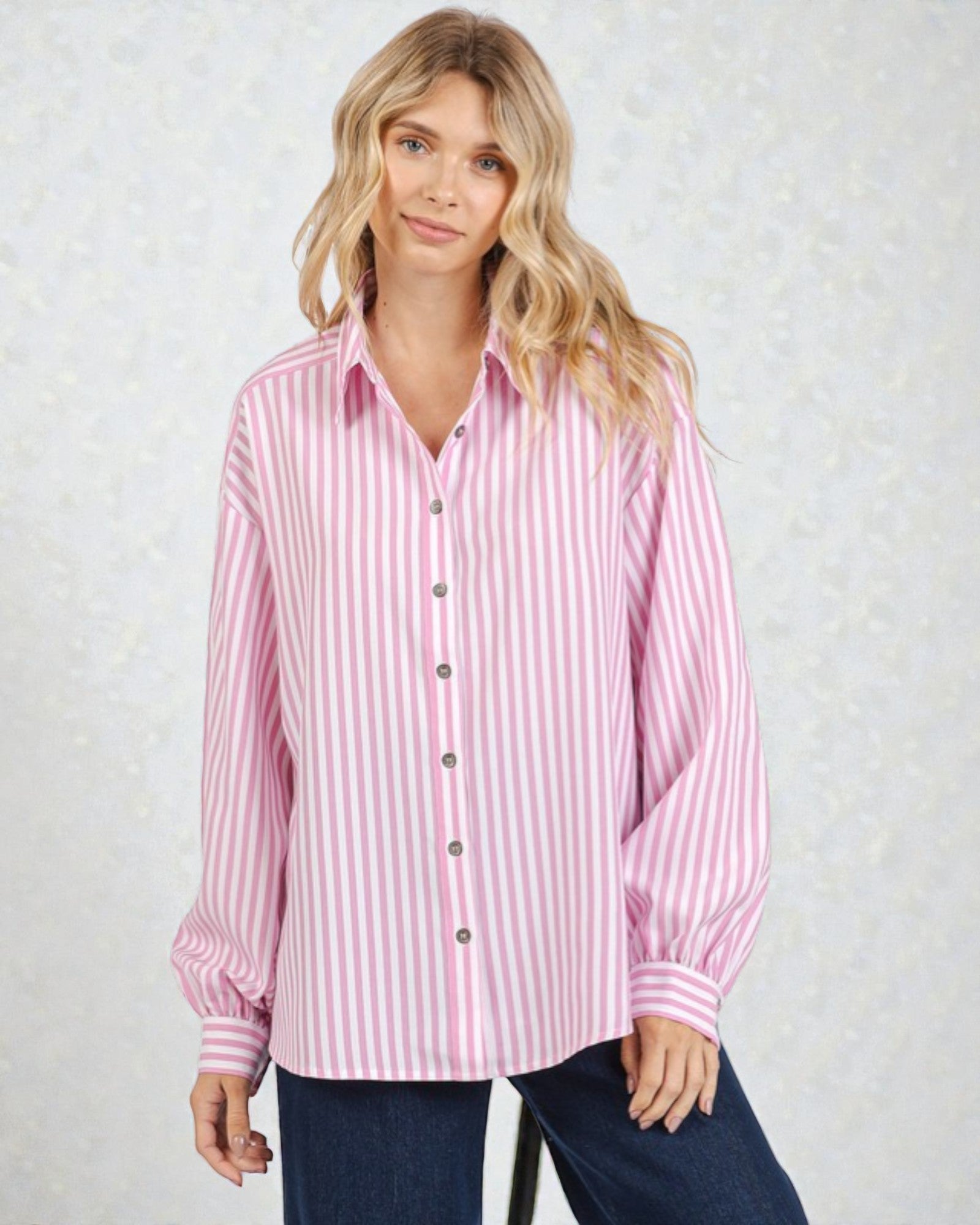 Woman wearing a pink and white striped shirt against a light background