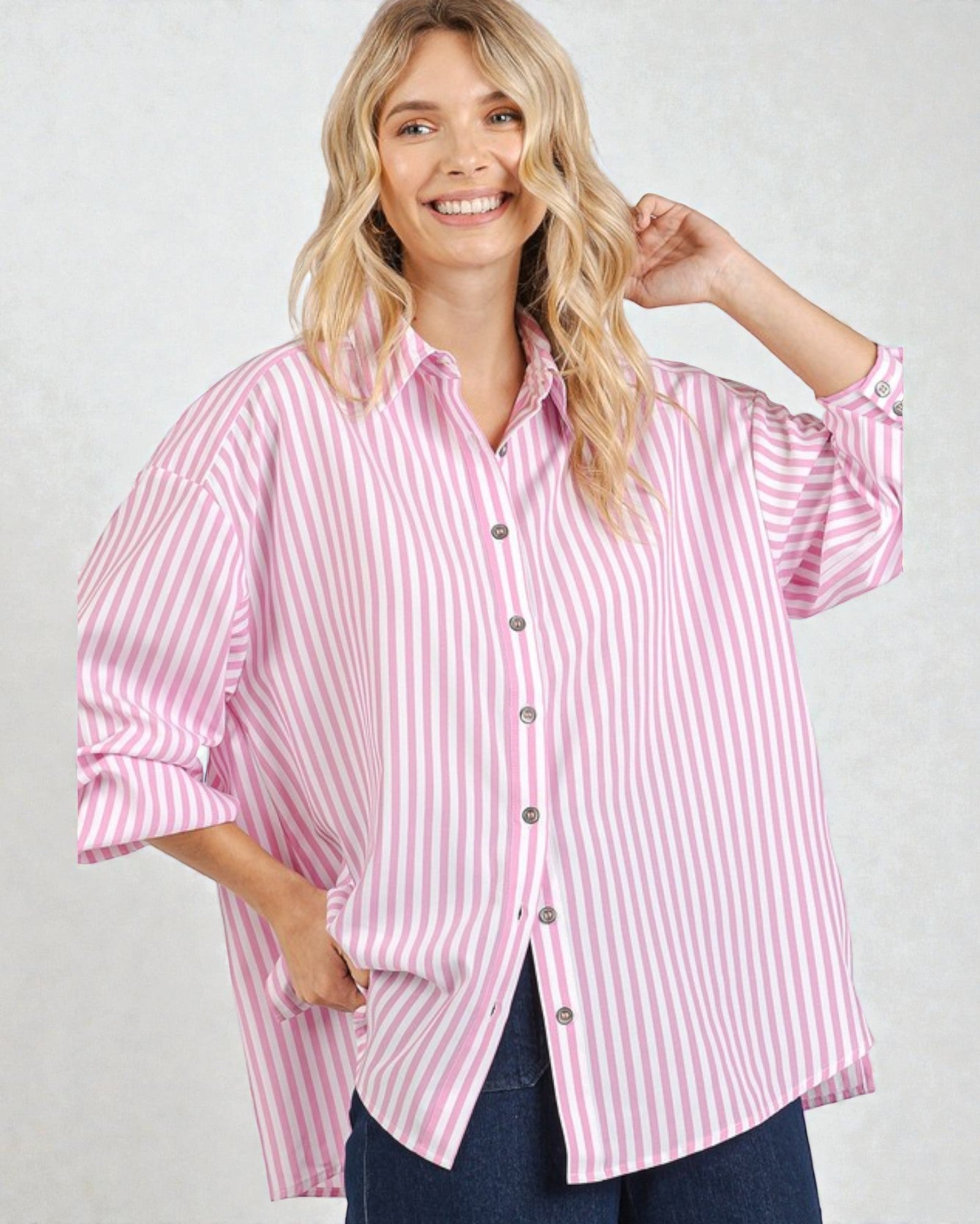 Woman wearing a pink and white striped shirt against a plain background