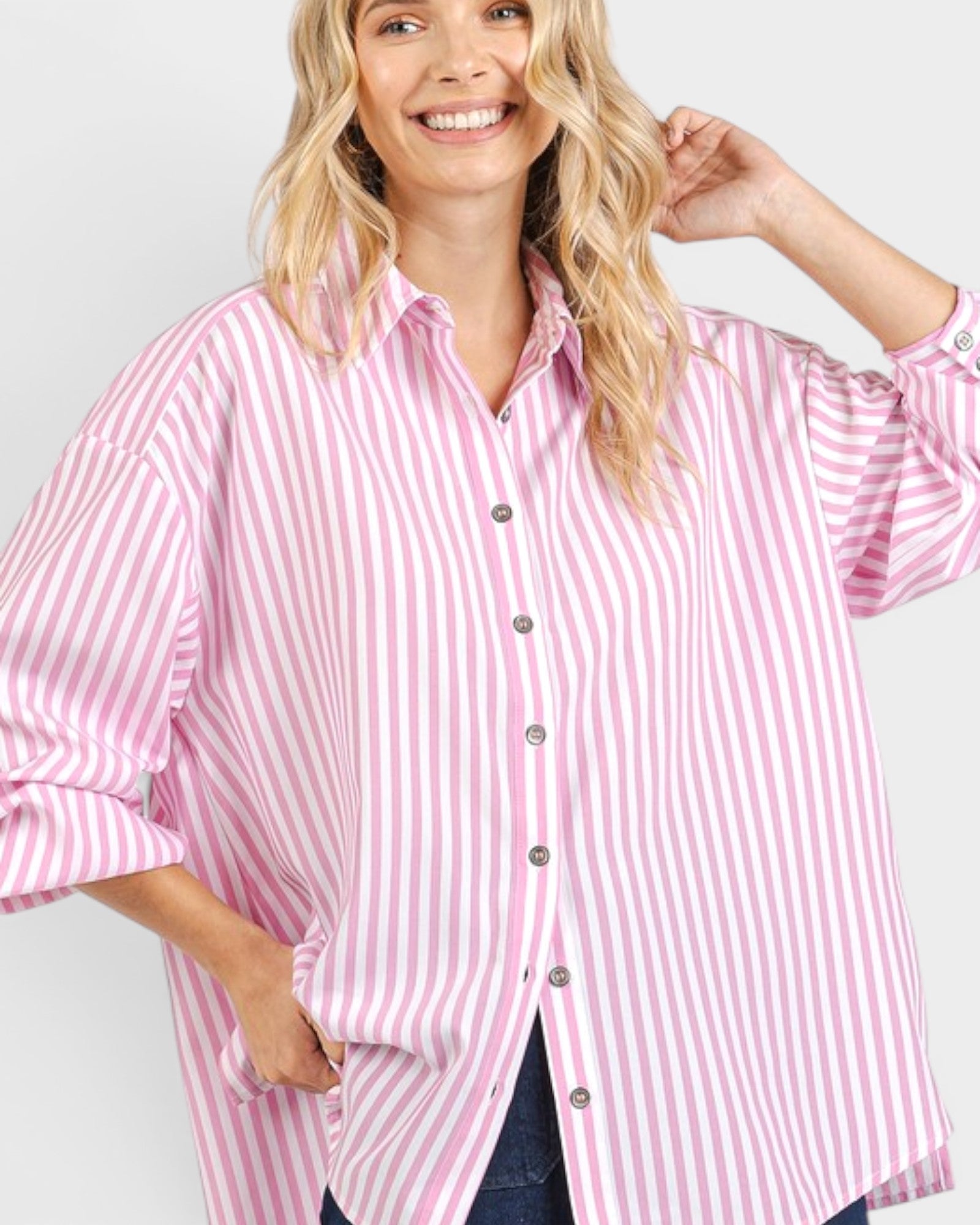Woman wearing a pink and white striped shirt against a plain background