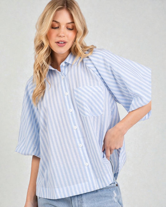 Woman wearing a light blue and white striped shirt against a plain background