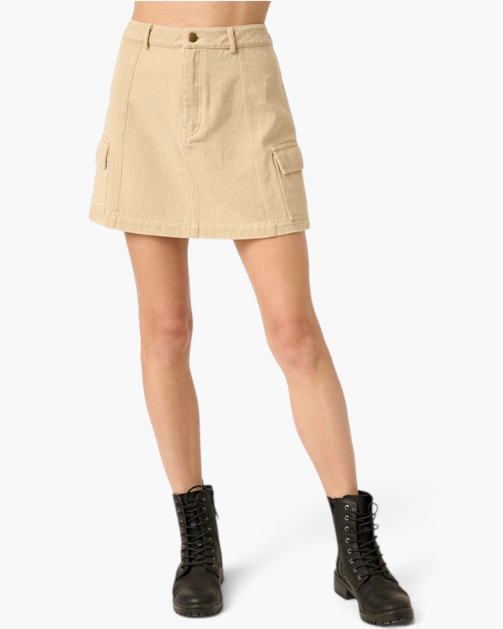 A beige corduroy cargo mini skirt with a button closure and side flap pockets, shown on a model wearing black combat boots against a light gray background.
