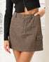 Brown mini skirt worn by a person on a white background