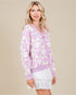 Woman wearing a purple cardigan with heart pattern on a beige background