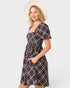 Woman wearing a plaid dress with a plain background