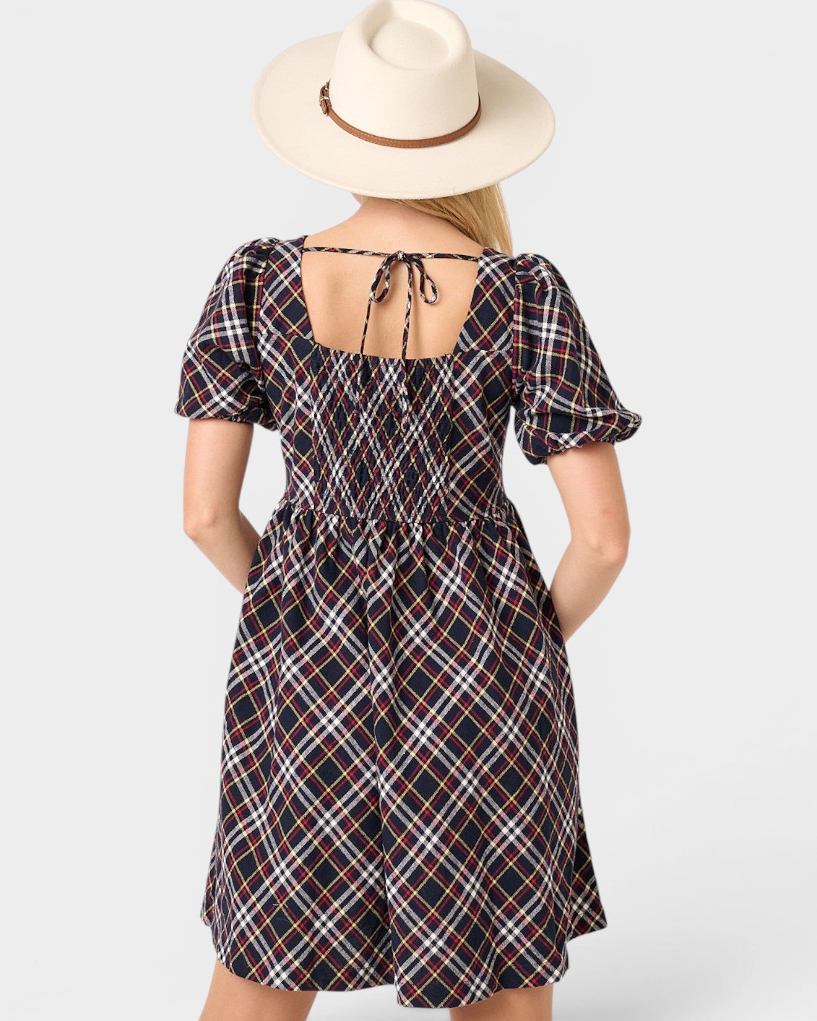 Woman wearing a plaid dress with a white background