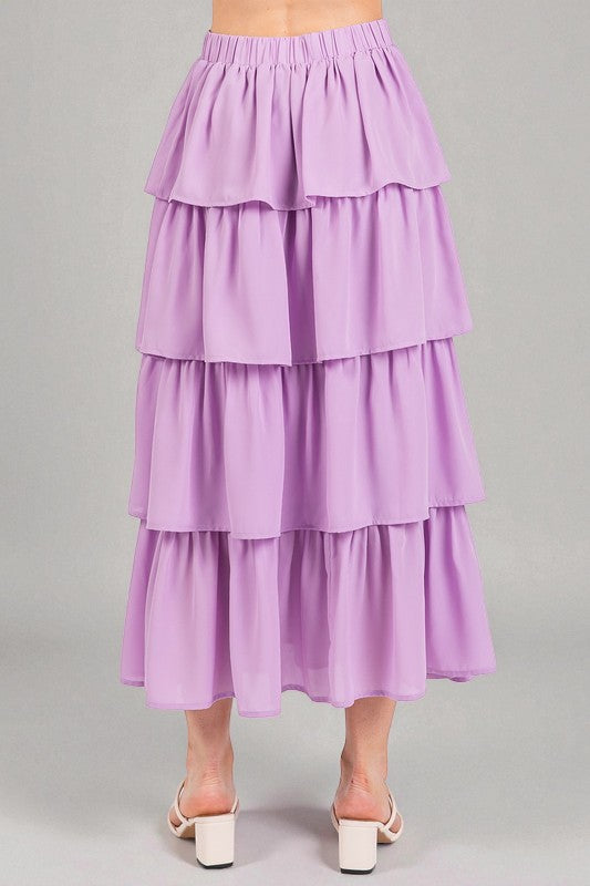 Purple tiered skirt worn by a person on a gray background