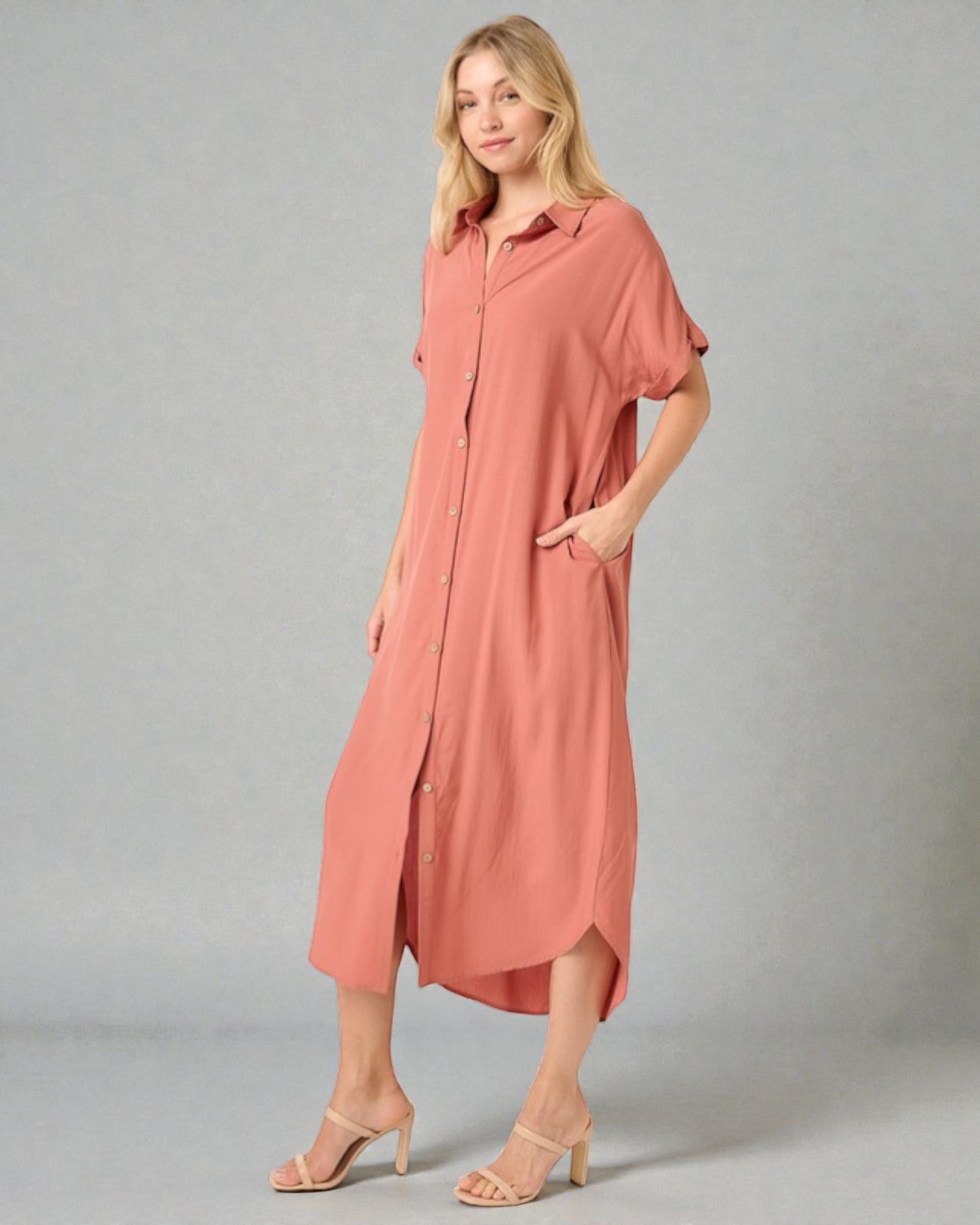 Woman wearing a long pink dress on a gray background