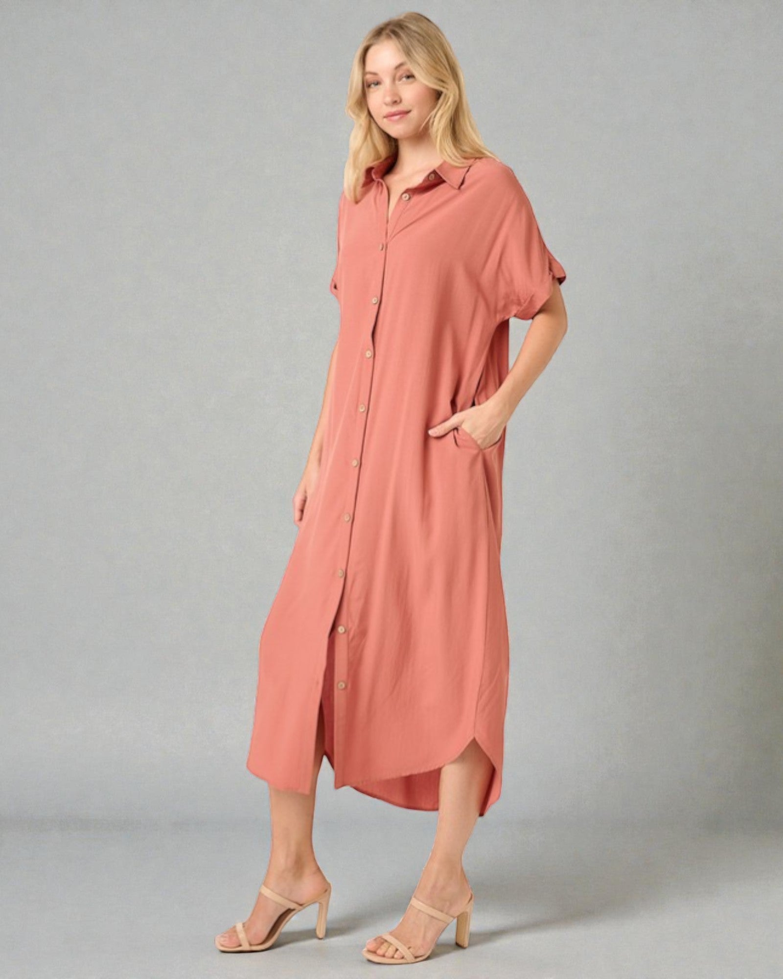 Woman wearing a long pink dress on a gray background