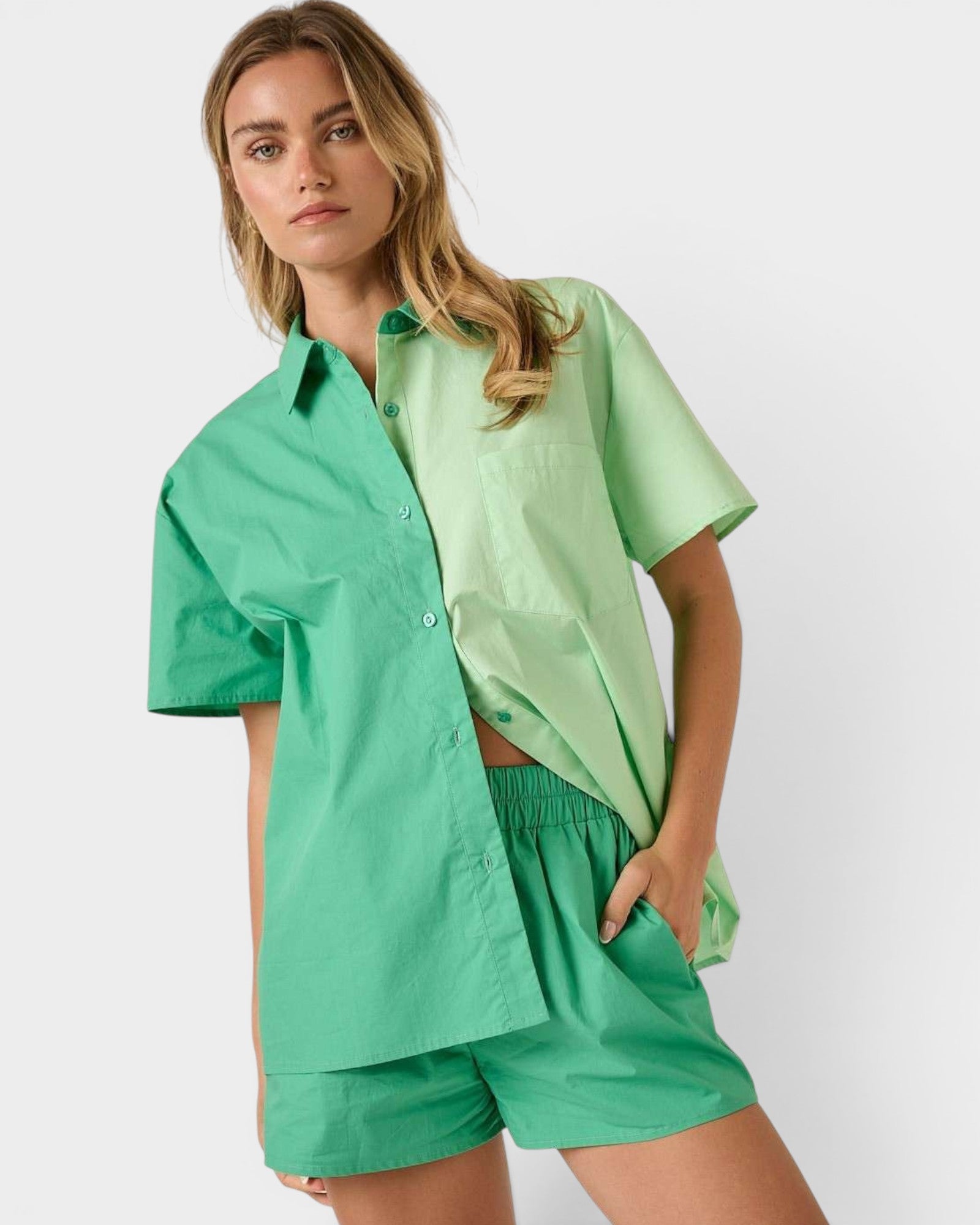 Woman wearing a green outfit with a shirt and shorts on a white background