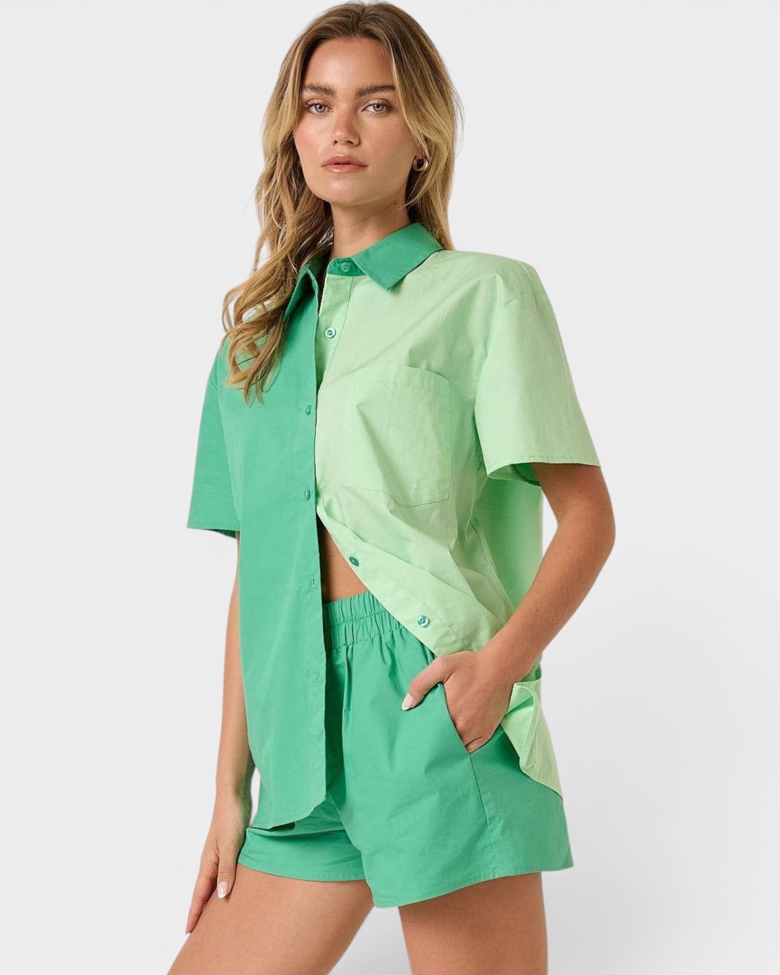 Woman wearing a green outfit with a shirt and shorts on a white background