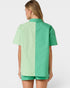 Person wearing a green and light green color-blocked shirt on a white background