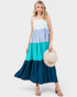 Woman wearing a multicolored dress holding a hat on a white background