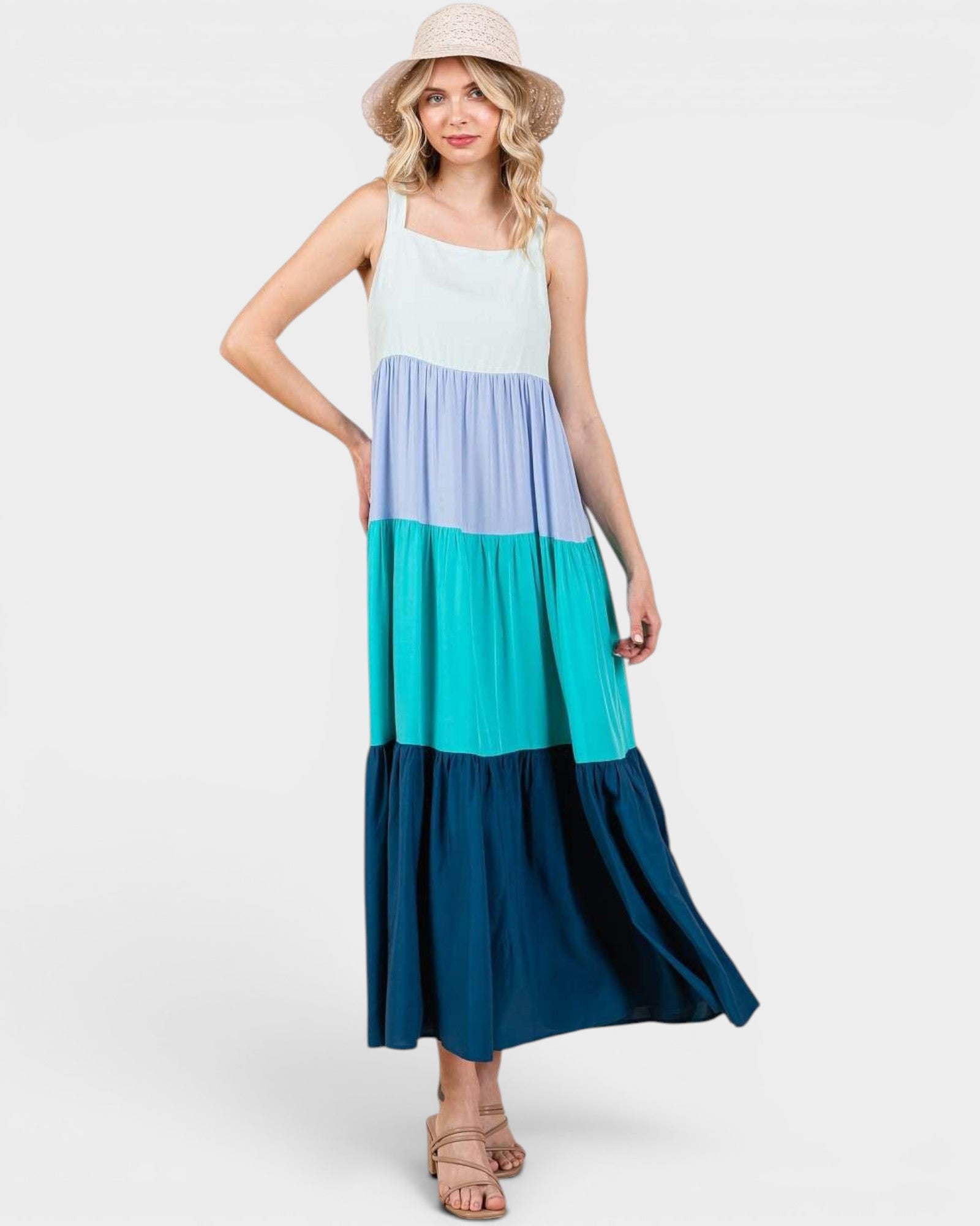 Woman wearing a color-blocked dress with a white, blue, and teal design on a white background