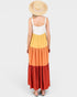 Woman wearing a multicolored dress with a white top and straw hat on a white background
