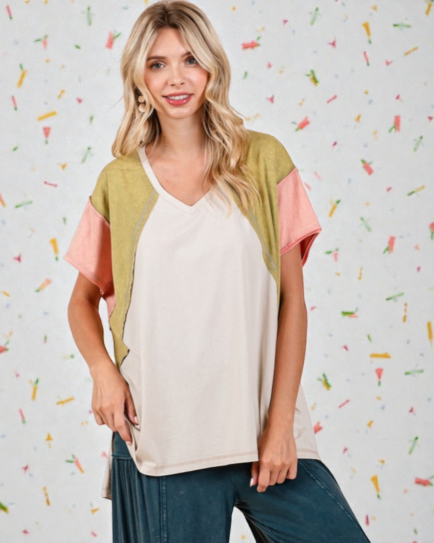 Woman wearing a colorful top with a patterned background