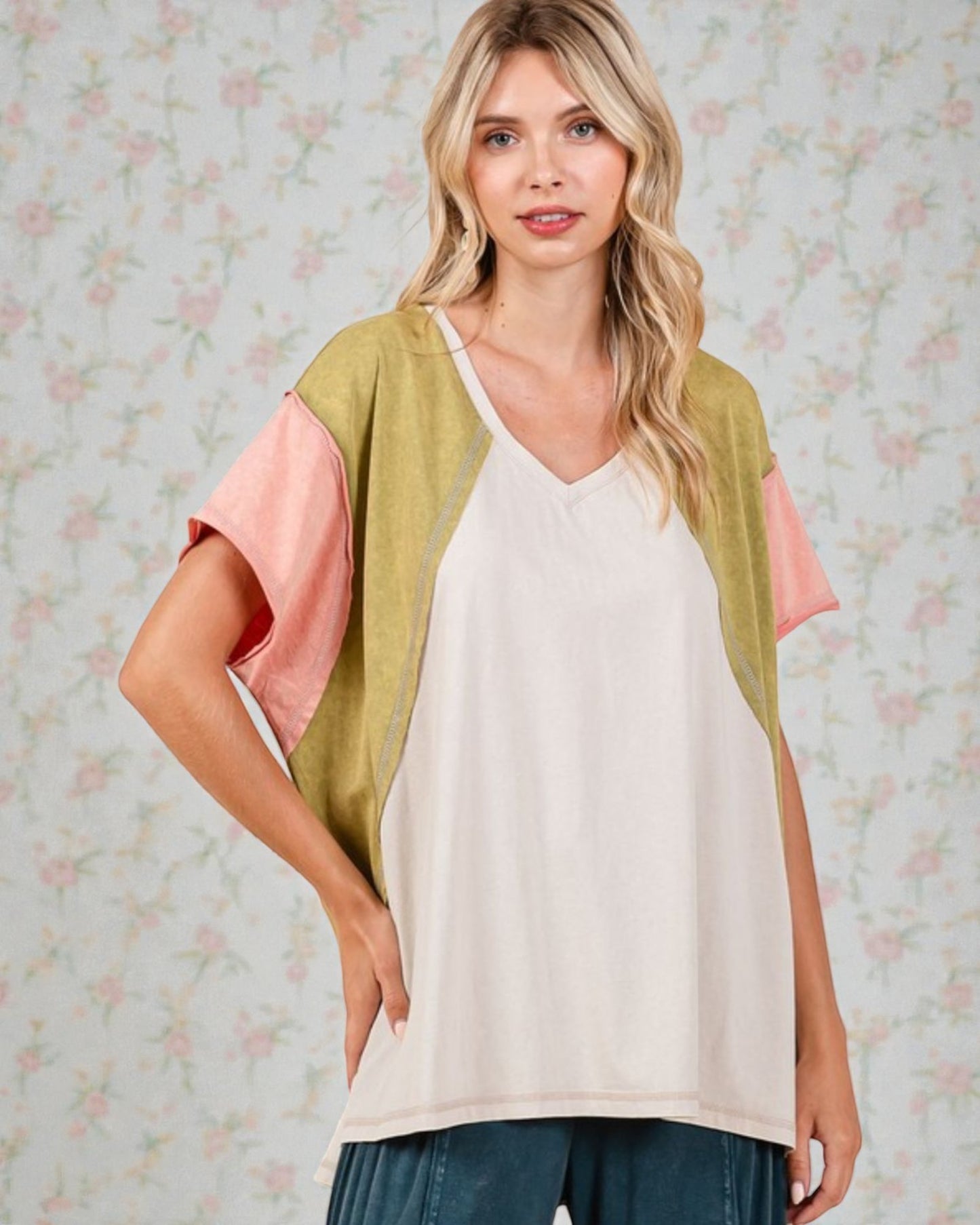 Woman wearing a colorful top with a floral patterned background