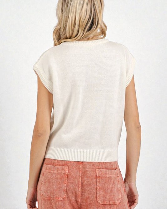 Person wearing a white sleeveless sweater over a pink skirt on a white background