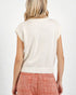 Person wearing a white sleeveless sweater over a pink skirt on a white background