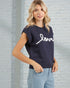 Woman wearing a navy sleeveless sweater with 'love' text against a light brick wall.