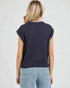 Person wearing a navy sleeveless sweater against a light background