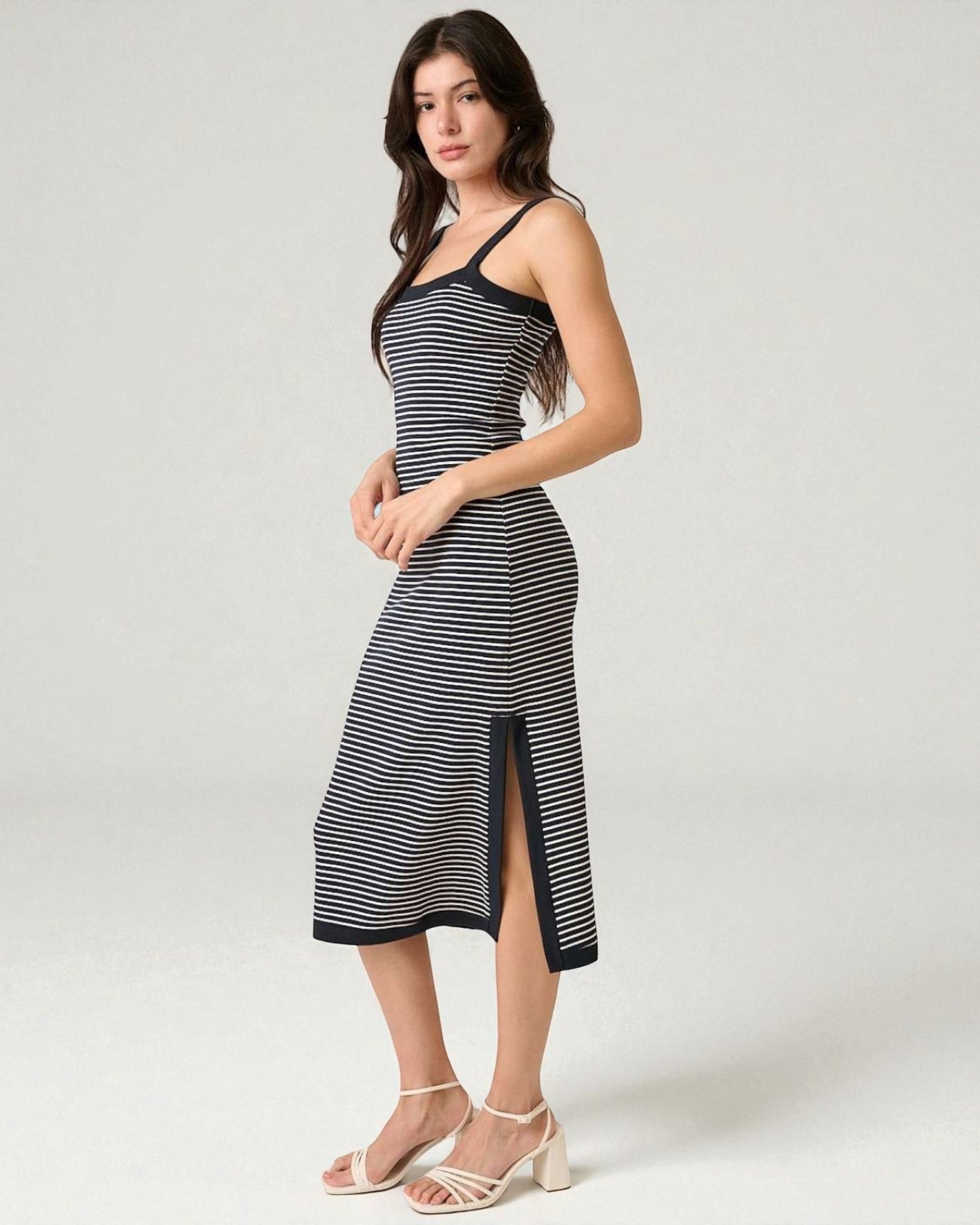 Woman wearing a black and white striped dress on a white background