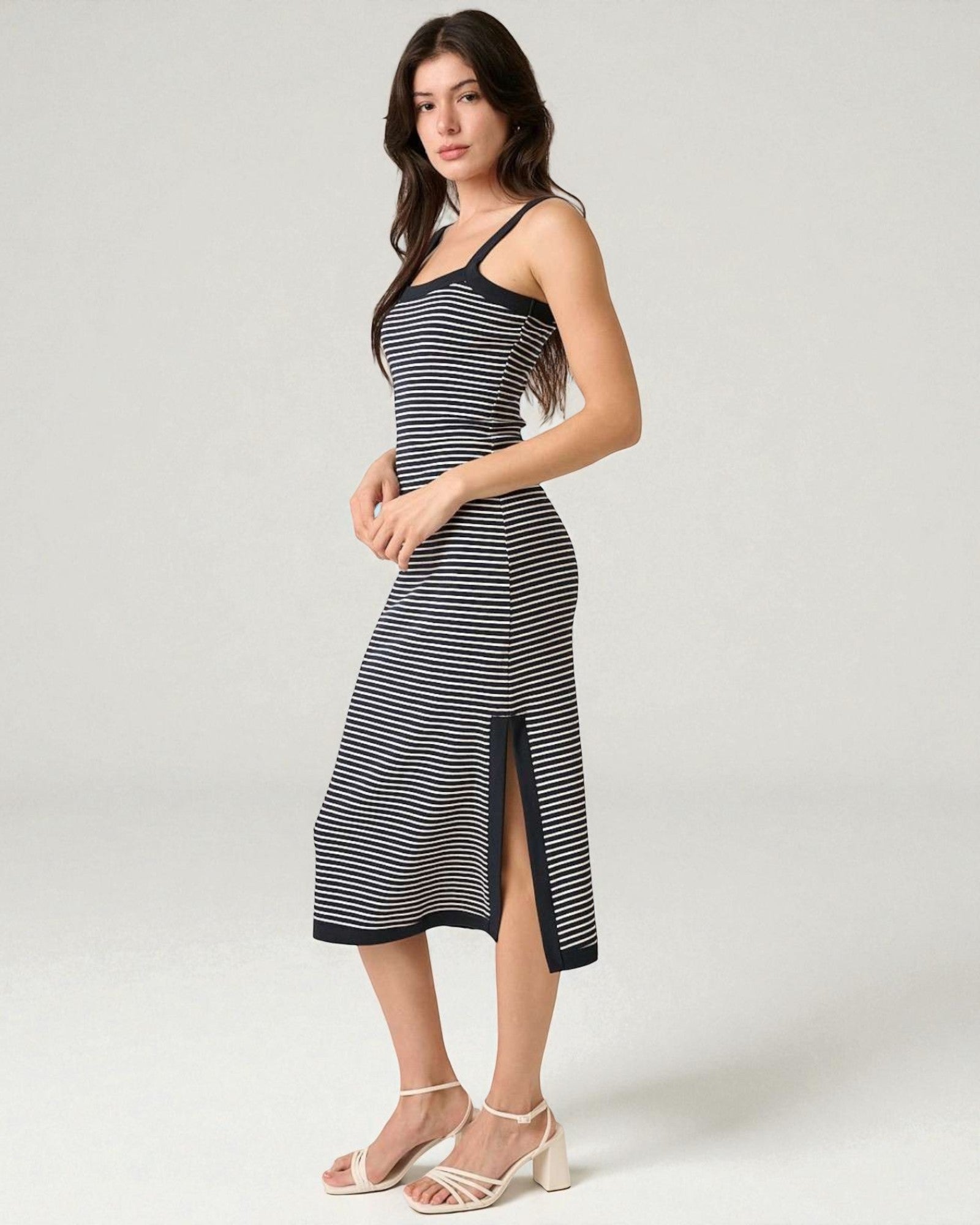 Woman wearing a black and white striped dress on a white background