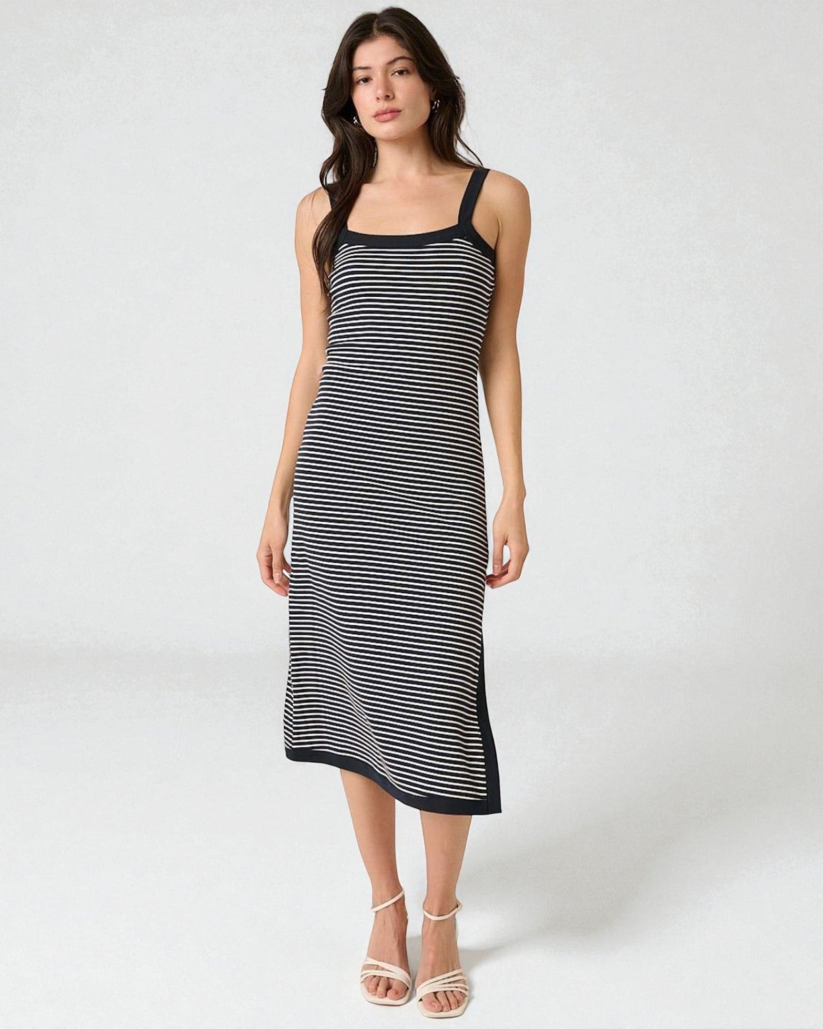 Woman wearing a black and white striped dress on a white background