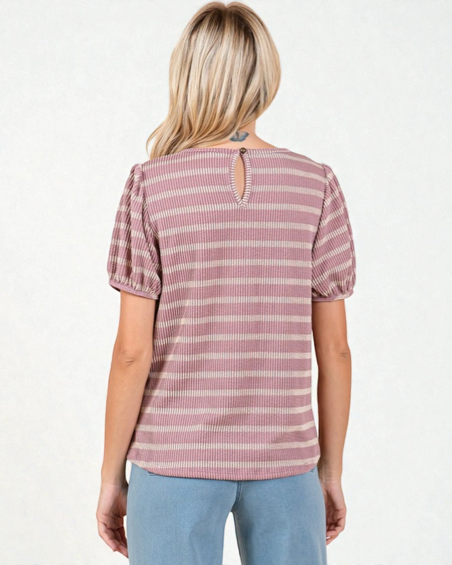 Woman wearing a pink and white striped blouse with puff sleeves on a white background