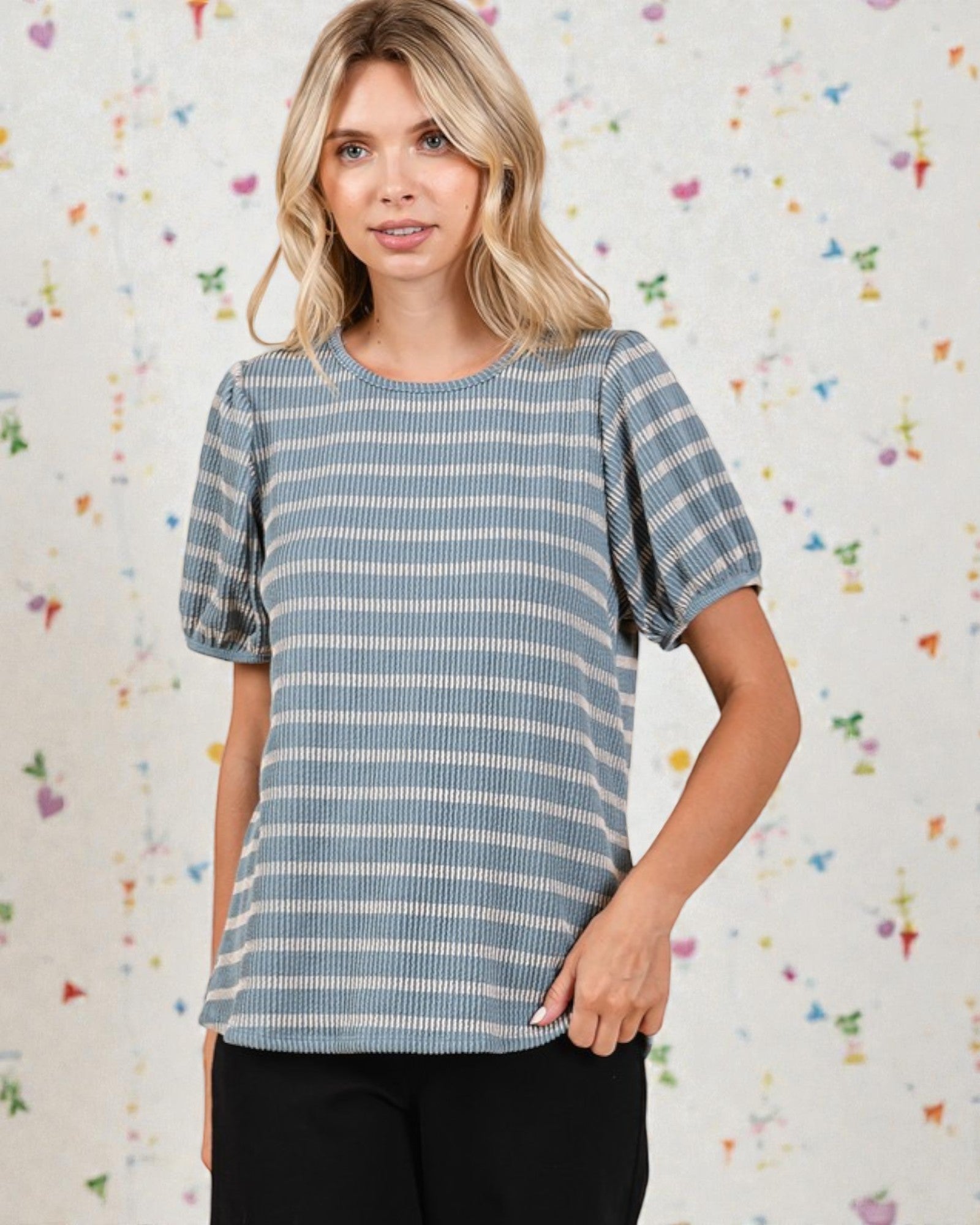 Woman wearing a blue and white striped shirt against a colorful abstract background