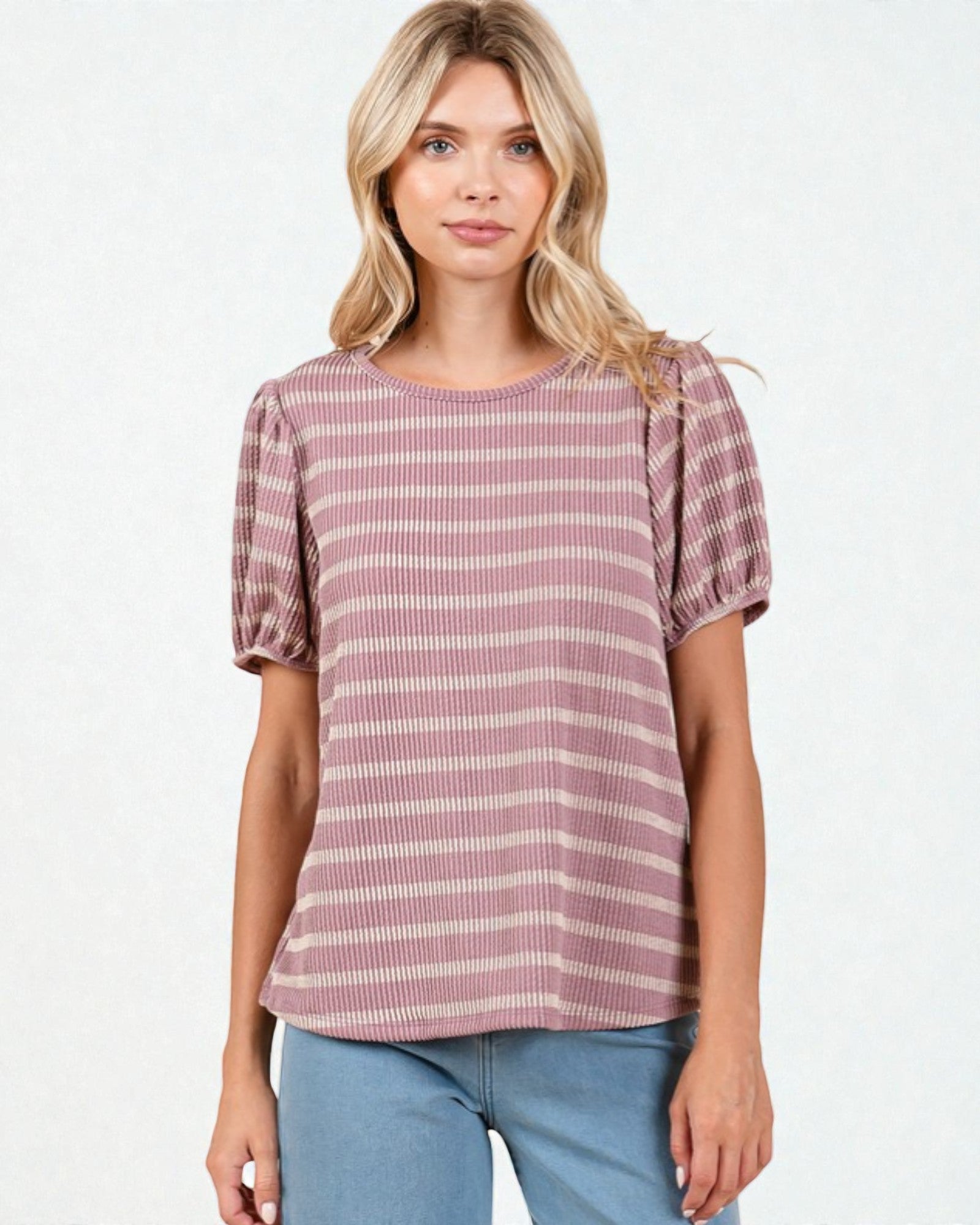 Woman wearing a striped shirt with puff sleeves on a white background