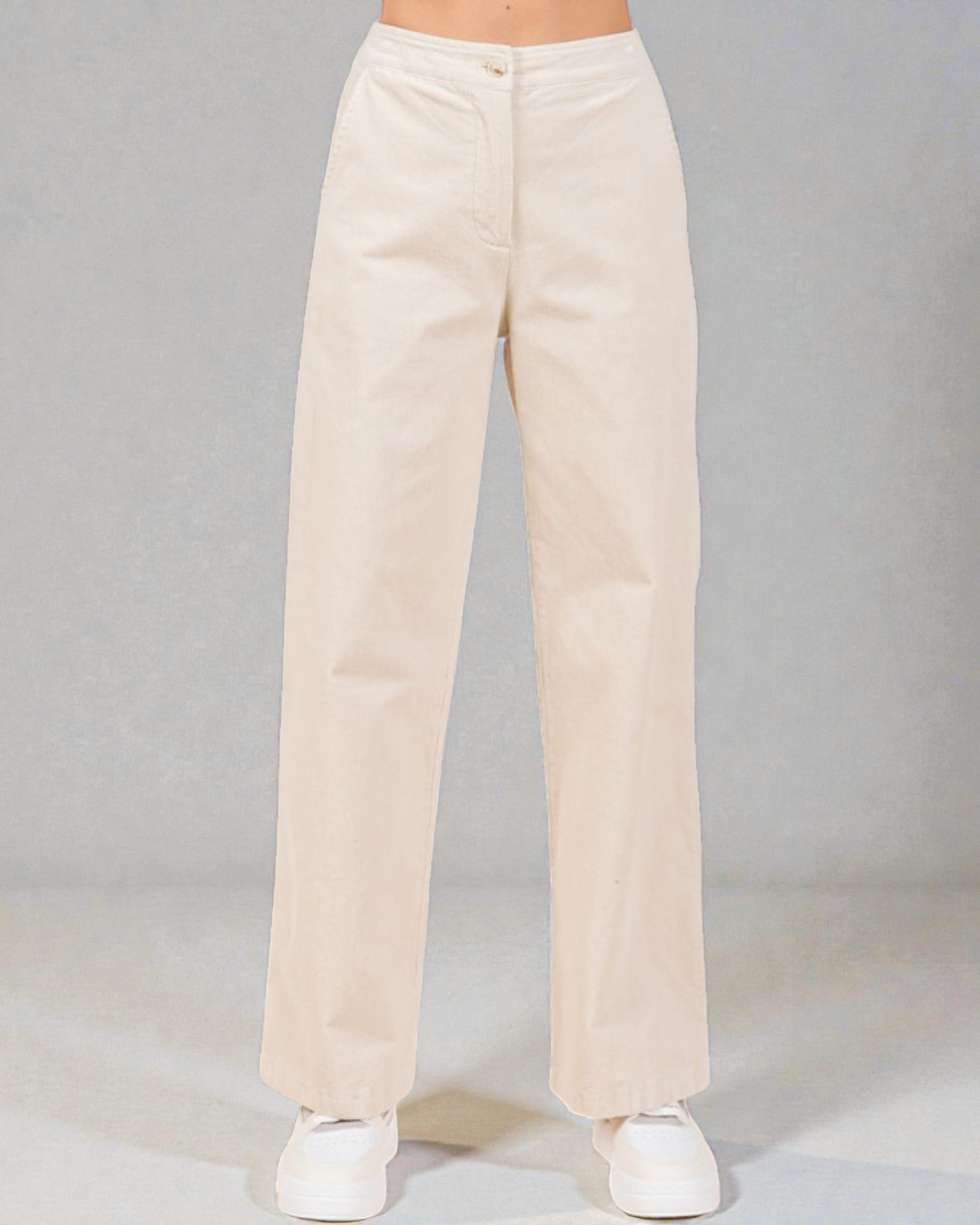 Beige pants worn by a person on a gray background