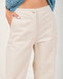 Beige pants worn by a person with a blue patterned top on a white background