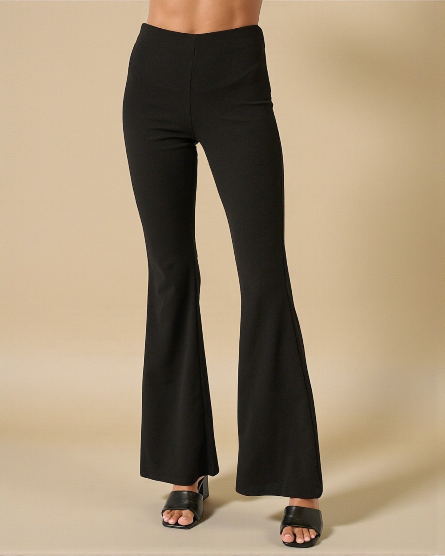 Black flared pants on a beige background
