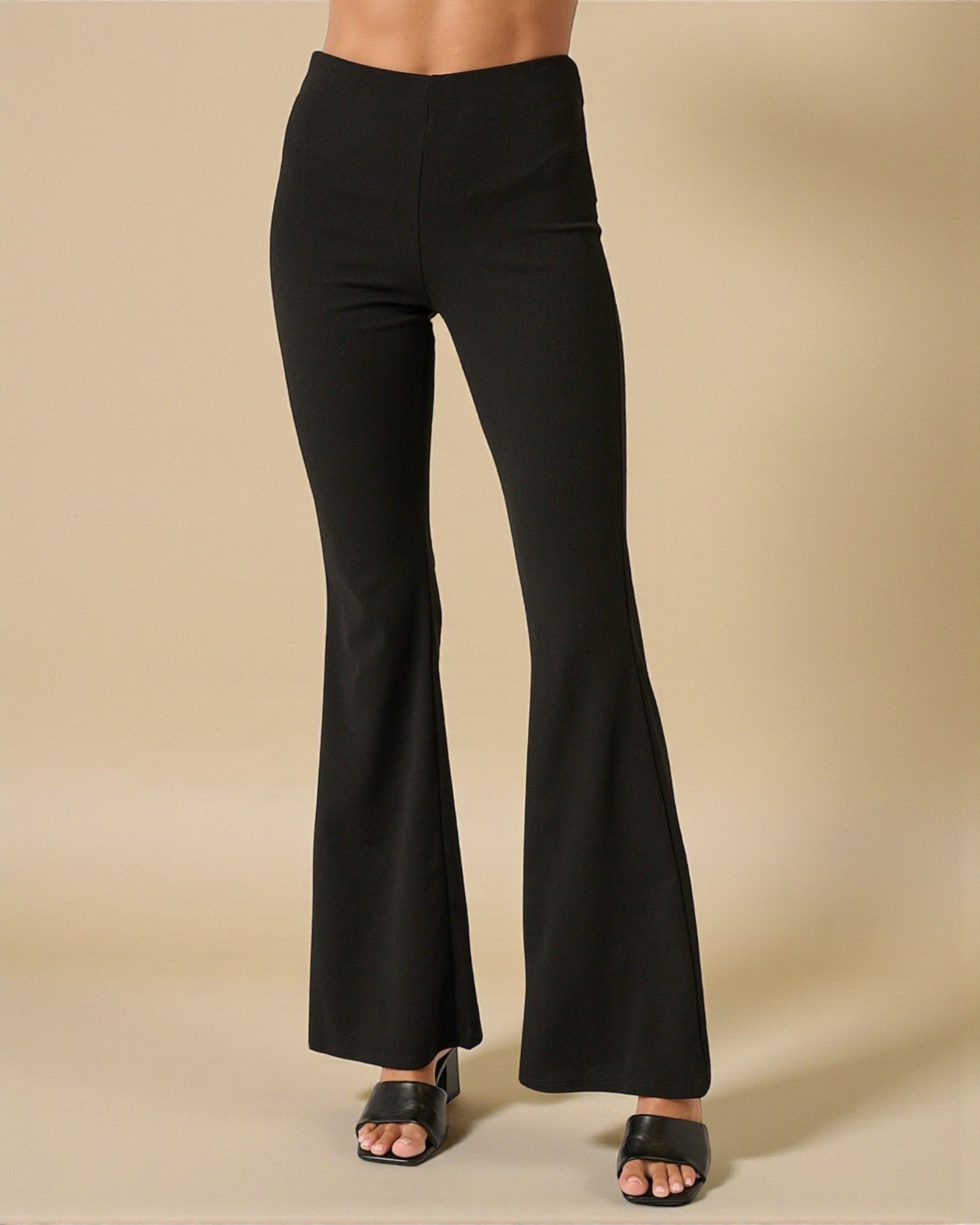 Black flared pants on a beige background