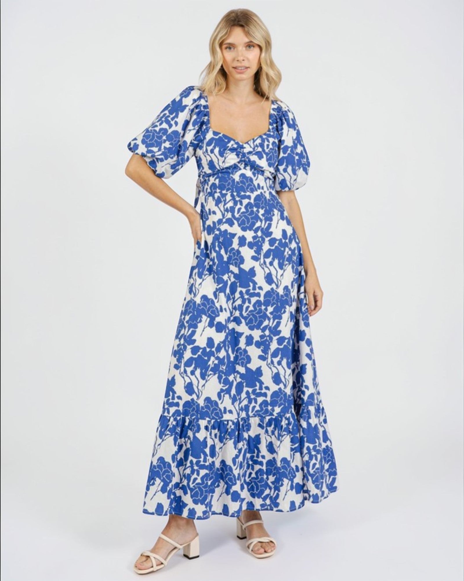 Woman wearing a blue floral dress on a white background