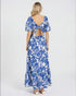 Woman wearing a blue floral dress with an open back on a white background
