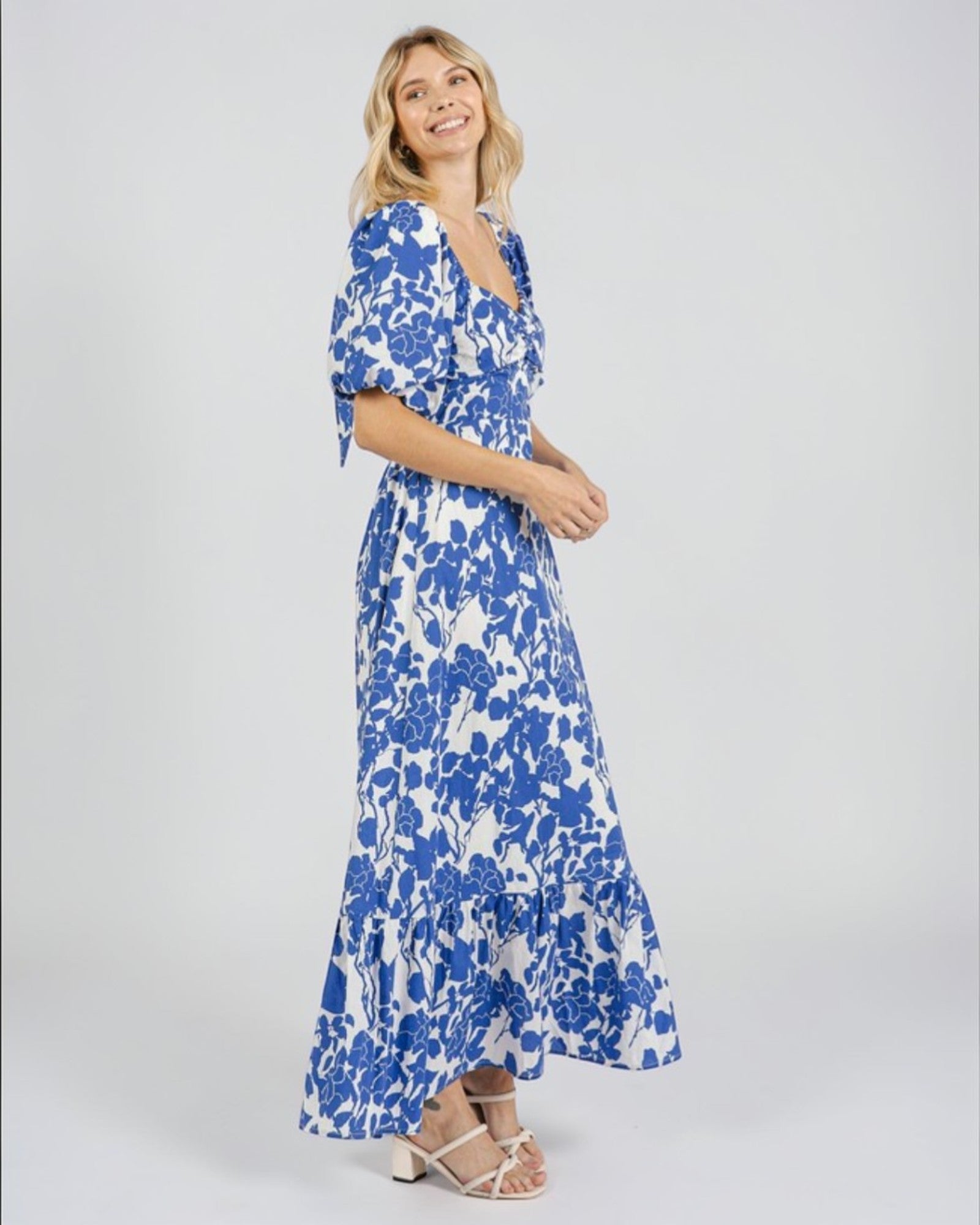 Woman wearing a blue floral dress on a white background
