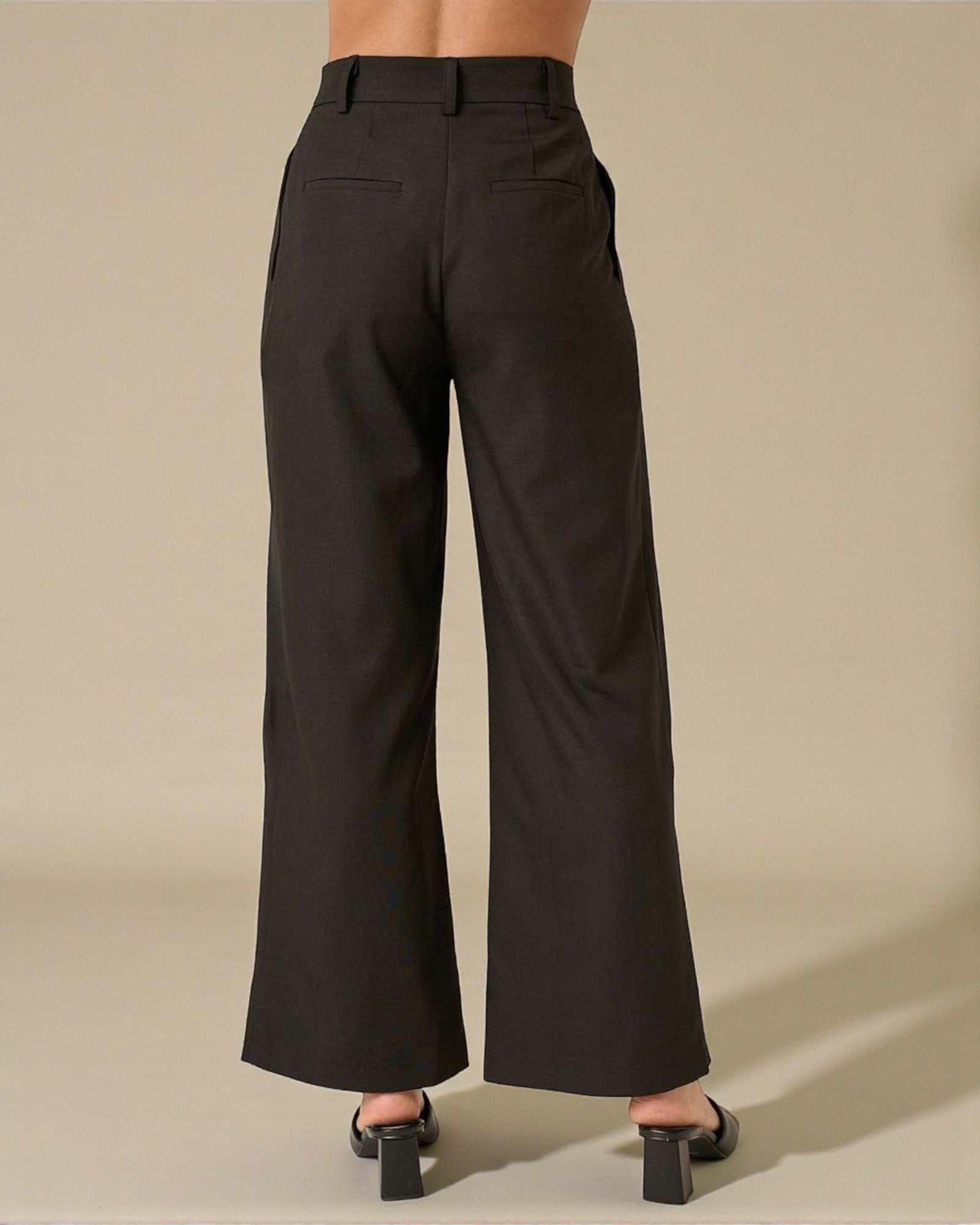 Black wide-leg pants worn by a person on a beige background