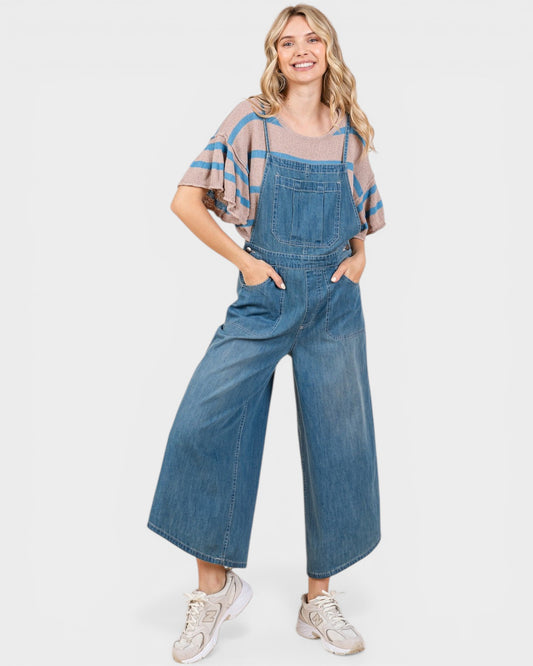 Woman wearing a denim jumpsuit on a white background