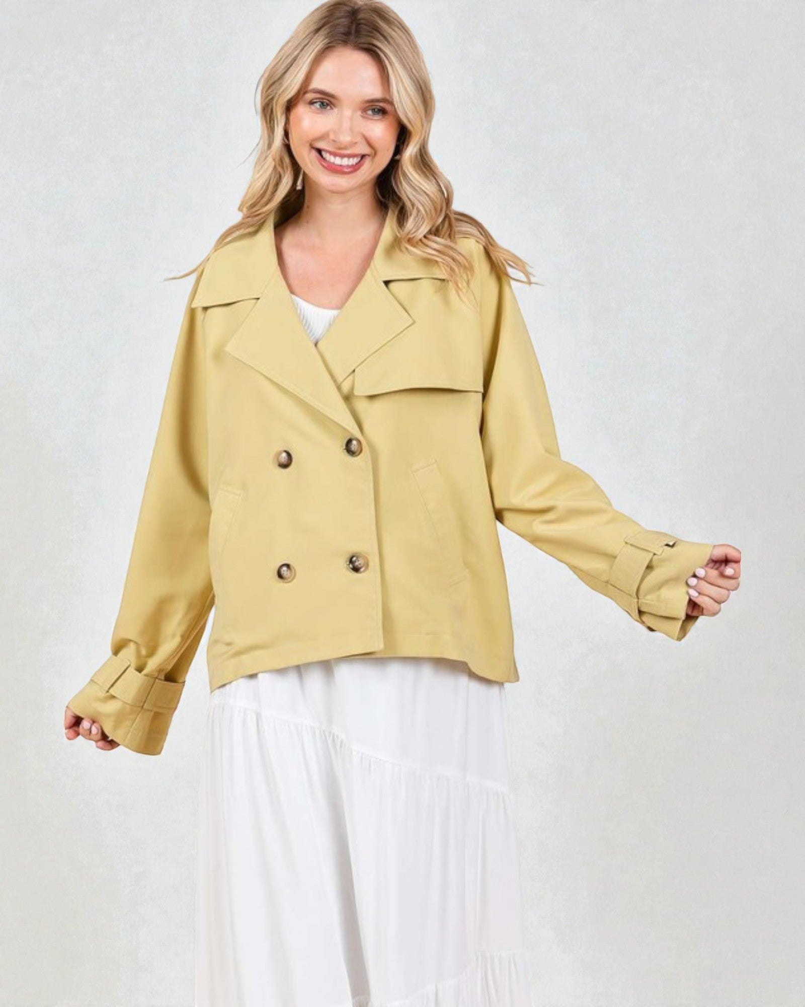 Woman wearing a mustard yellow jacket on a white background