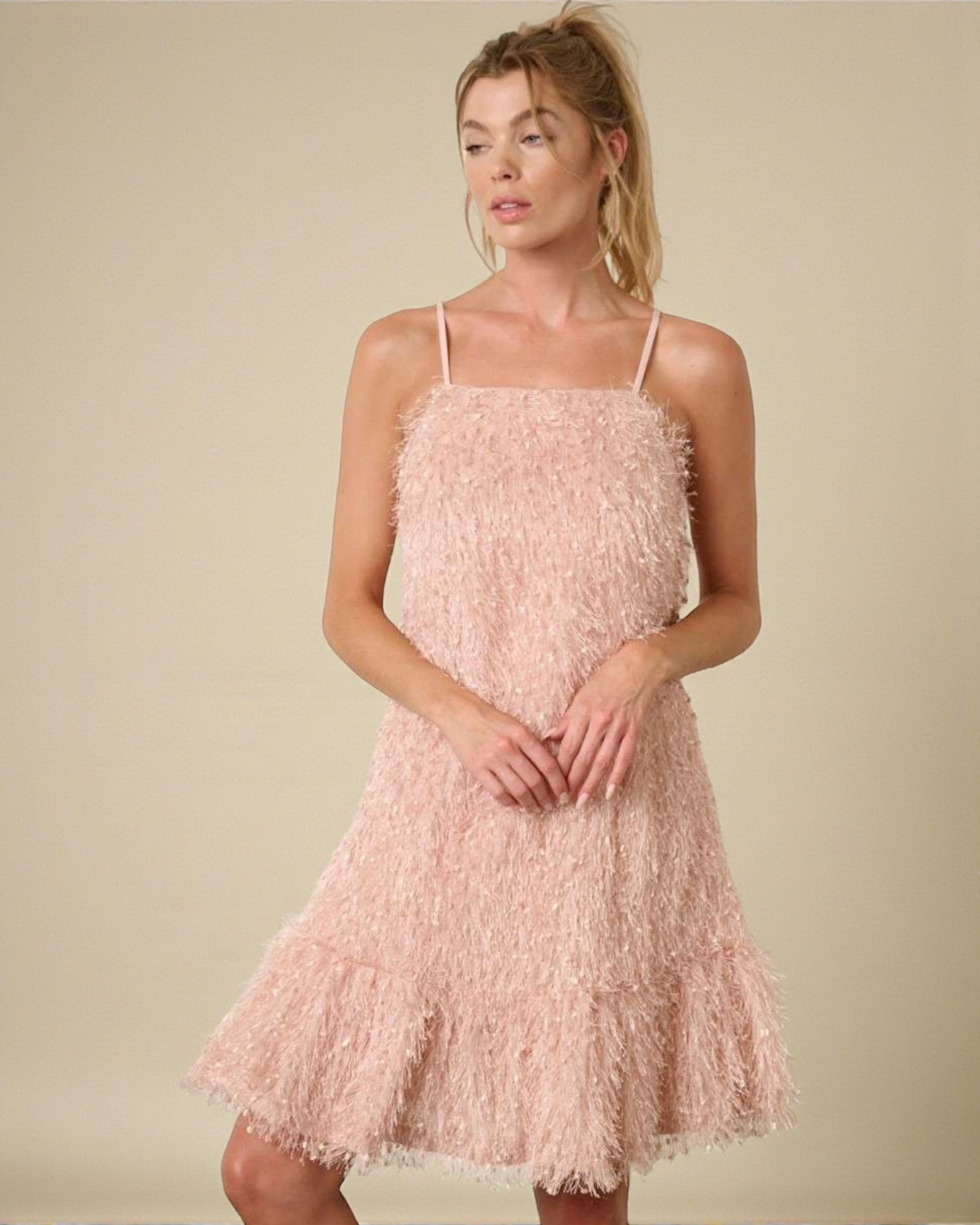 Woman wearing a pink textured dress against a beige background