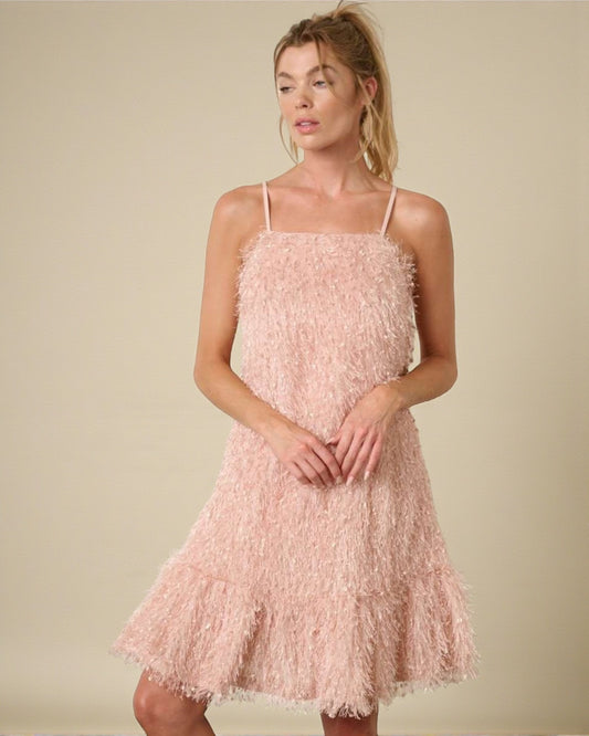 Woman wearing a pink textured dress against a beige background