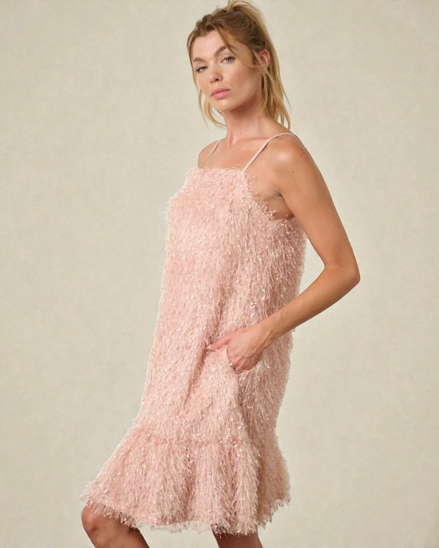 Woman wearing a pink textured dress against a neutral background