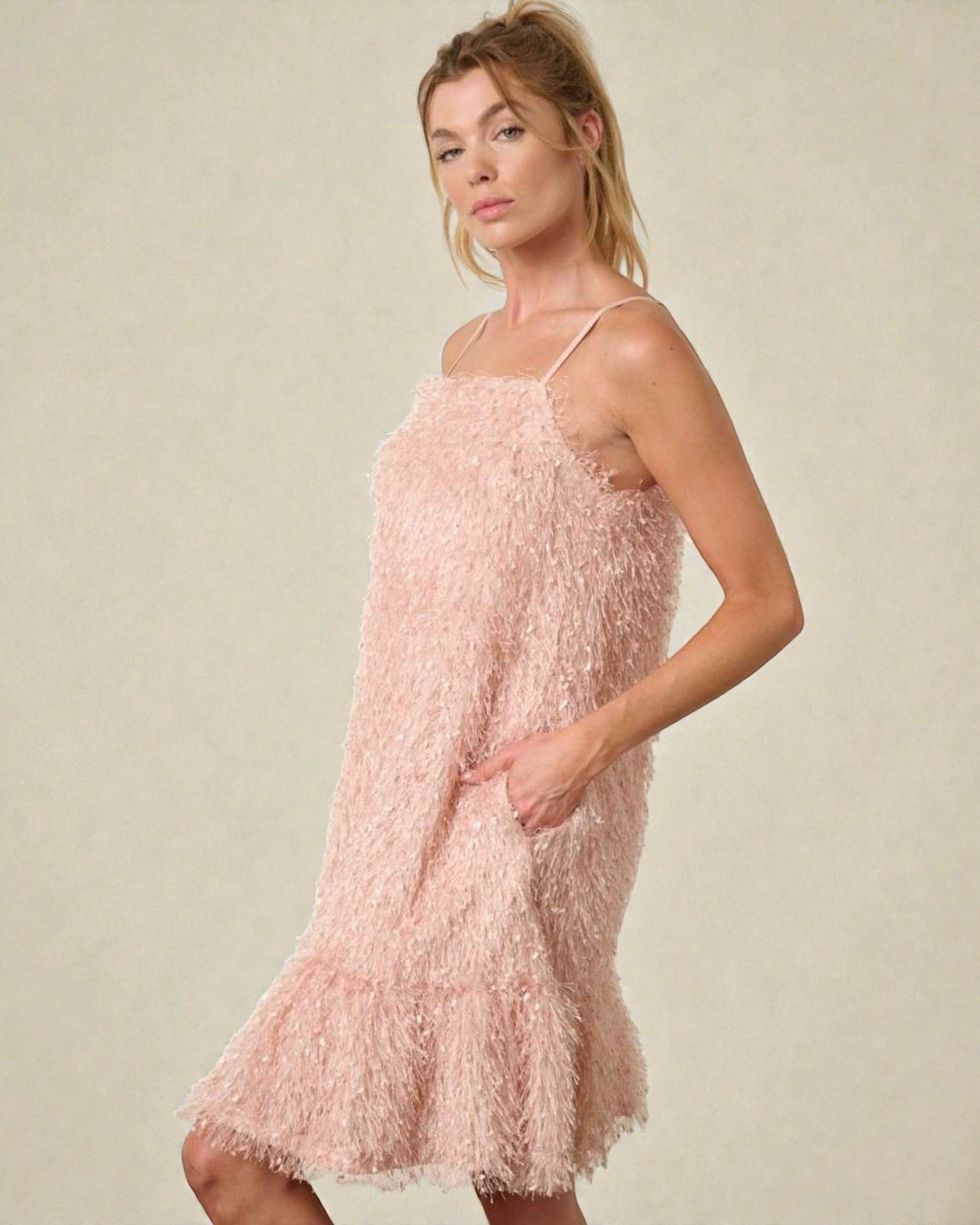 Woman wearing a pink textured dress against a neutral background